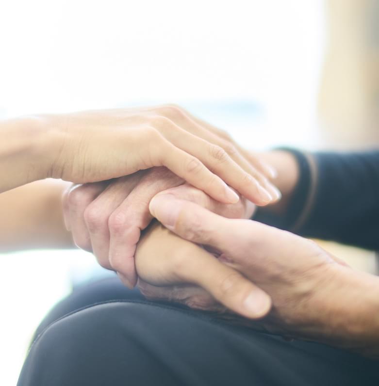 利用者様の手に優しく手を添える介護士